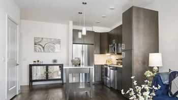 a kitchen and living room with stainless steel appliances and a table